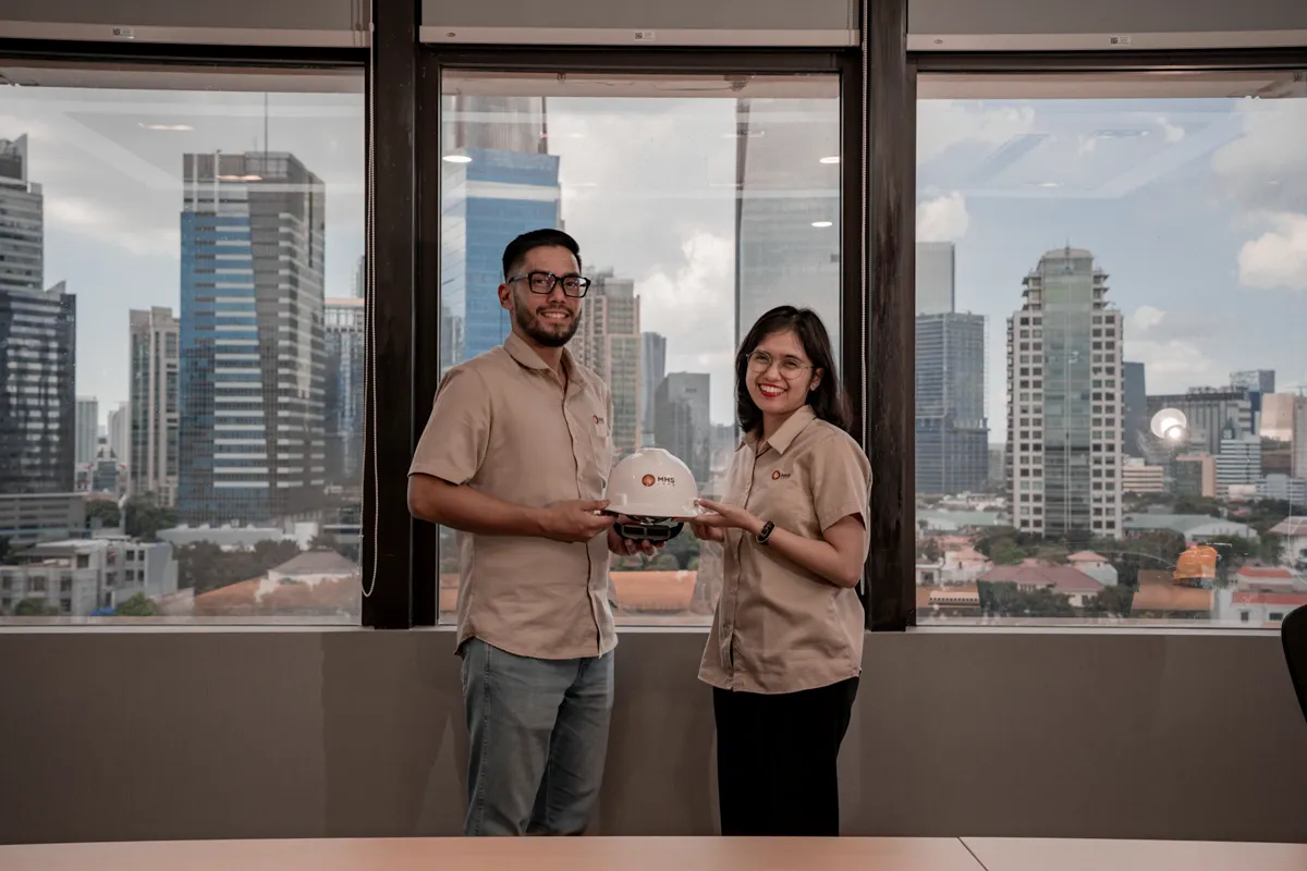 Two engineers with a hard hat in an office over a city